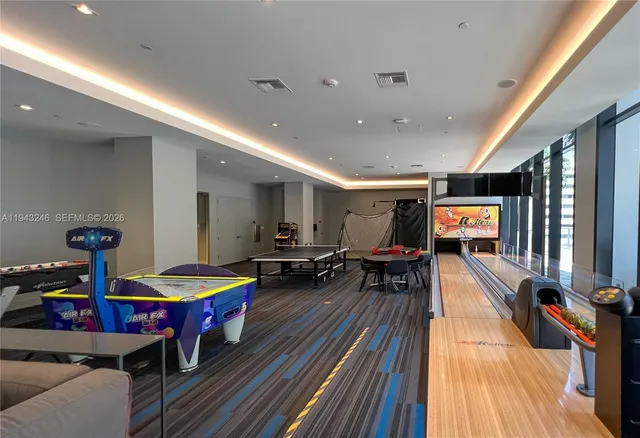 a living room with furniture flat screen tv and pool table