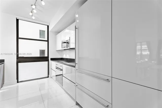 a kitchen with stainless steel appliances granite countertop a refrigerator and a stove