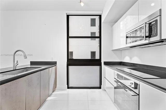 a kitchen with stainless steel appliances a sink and a refrigerator