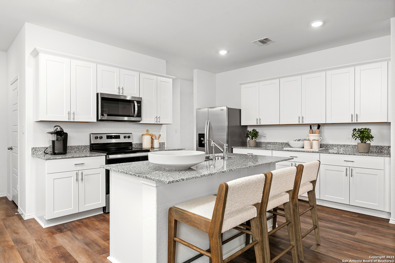 405 Raven Row Marion, TX 78124 - Photo 12 of 25 a kitchen with stainless steel appliances granite countertop a stove a sink a microwave a refrigerator and white cabinets