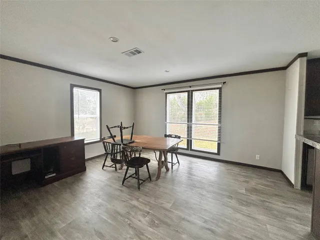 a large kitchen with a large counter top a sink stainless steel appliances and cabinets