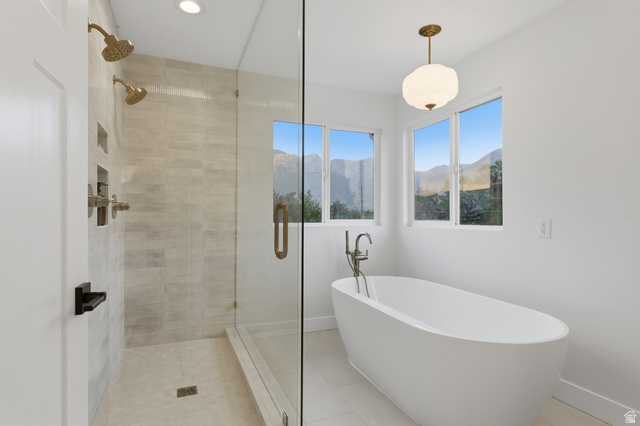 702 Alpine Highway Alpine, UT 84004 - Photo 51 of 83 Spacious bathroom featuring a frameless glass shower enclosure, dual shower heads with gold-tone fixtures, a freestanding soaking tub, and multiple windows with mountain scenery