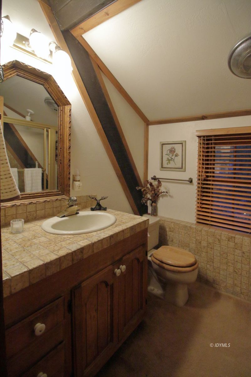 24745 Fern Valley Road Idyllwild, CA 92549 - Photo 21 of 48 a bathroom with a double vanity sink toilet and a mirror