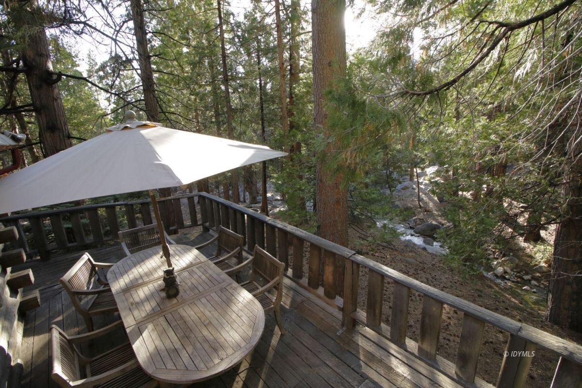24745 Fern Valley Road Idyllwild, CA 92549 - Photo 30 of 48 a balcony with wooden floor table and chairs