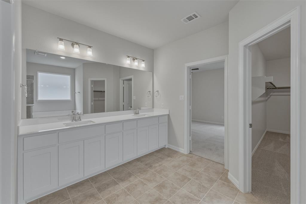1325 Frio Drive Springtown, TX 76082 - Photo 16 of 24 Spacious bathroom featuring a dual vanity with white cabinetry, quartz-finish countertops, and two undermount sinks