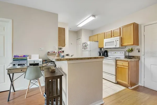 a kitchen with kitchen island granite countertop a sink cabinets and wooden floor