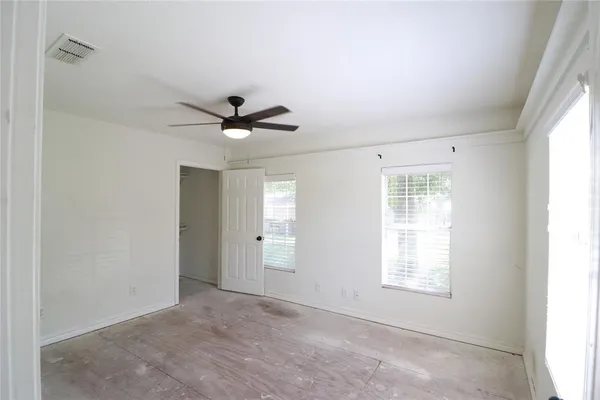 a view of a room with a ceiling fan and a large window