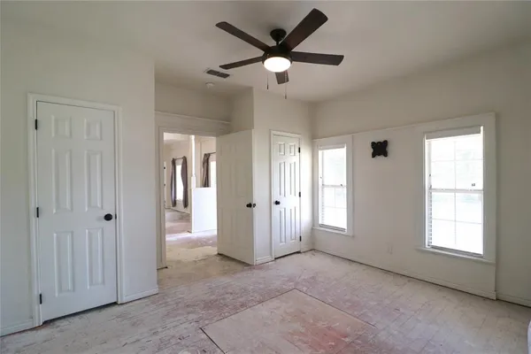 an empty room and chandelier fan