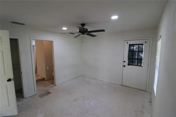 a view of an empty room and a ceiling fan window