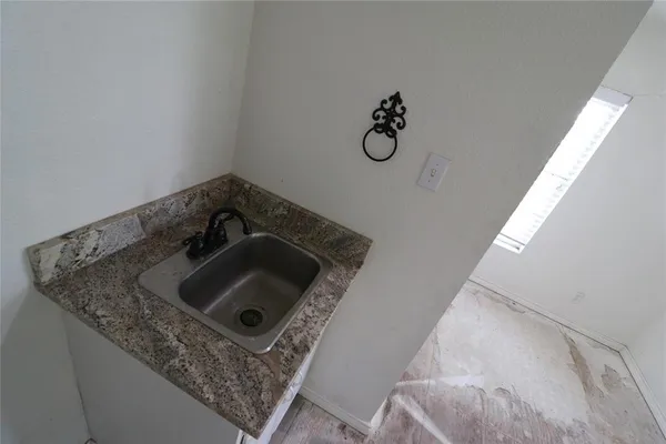 a view of a hallway with wooden floor and a bathroom