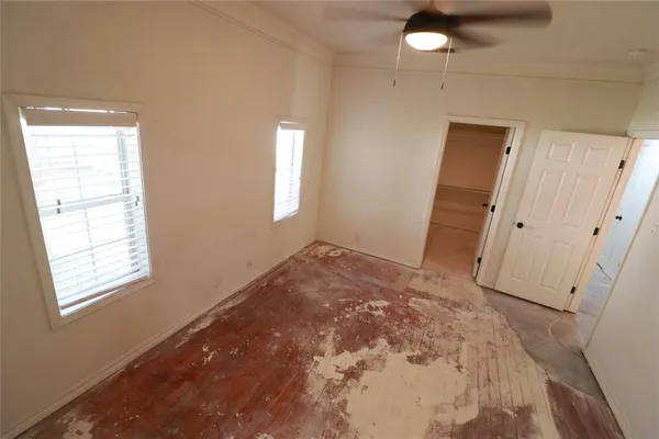 an empty room with closet and windows