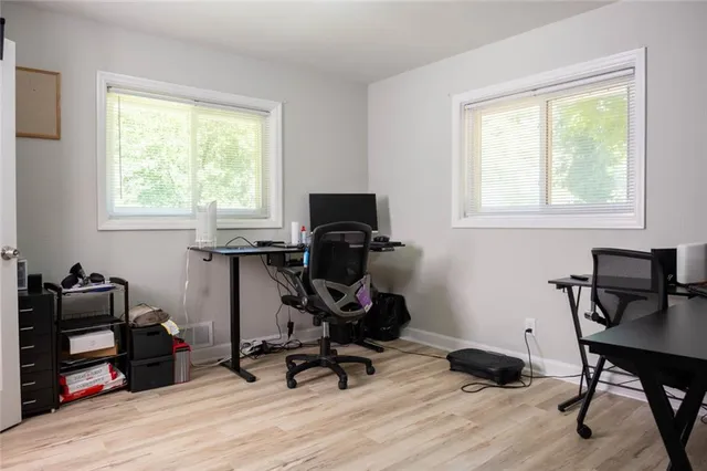 a view of a workspace with furniture and a window