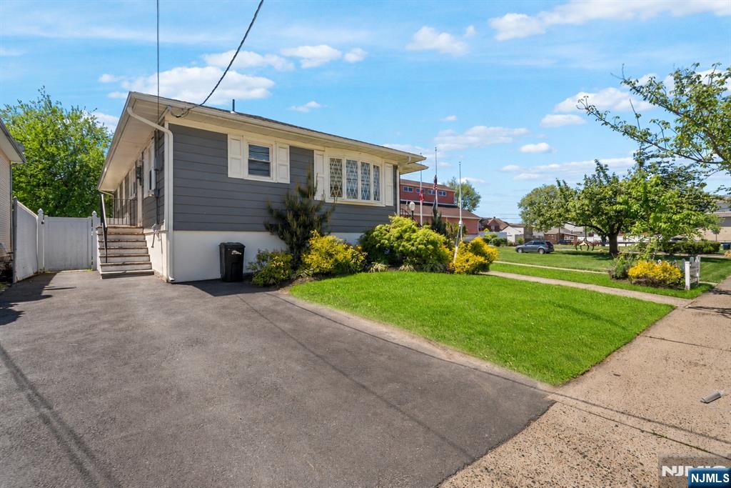 112 Garibaldi Avenue Lodi, NJ 07644 - Photo 31 of 31 a front view of a house with a garden and plants