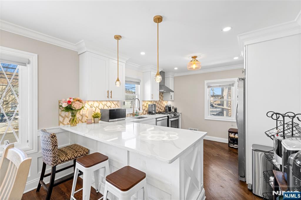 112 Garibaldi Avenue Lodi, NJ 07644 - Photo 8 of 31 a kitchen with kitchen island a stove a table and chairs in it