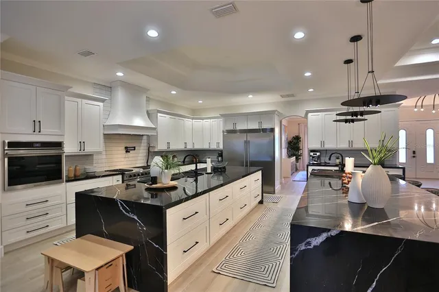 a kitchen that has a lot of cabinets a sink and appliances