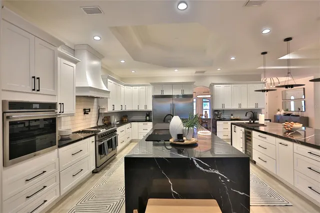 a kitchen with stainless steel appliances kitchen island granite countertop a sink counter space and cabinets