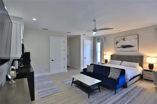 a spacious bedroom with a bed and wooden floor