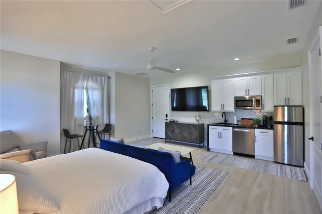 a large bedroom with a bed and a flat screen tv