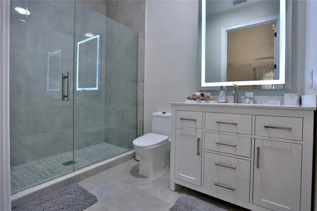 a bathroom with a granite countertop sink toilet and shower