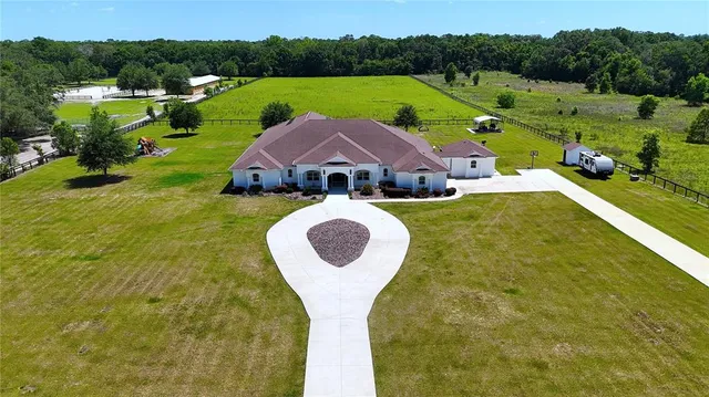 a aerial view of a house with pool garden and a yard