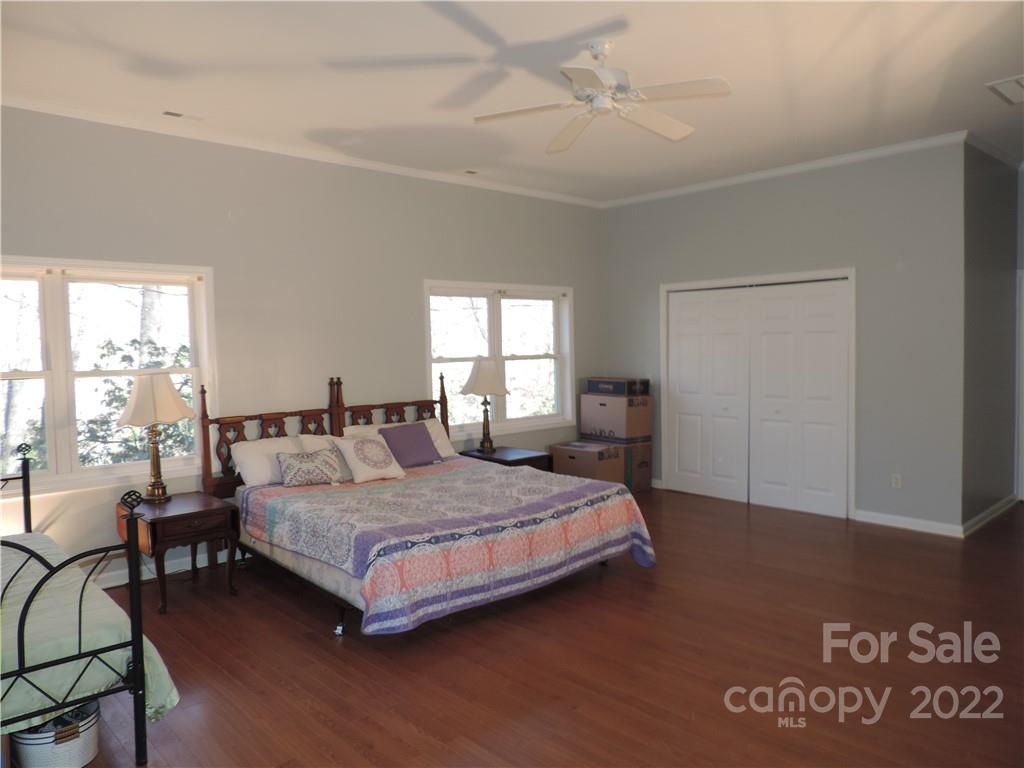 3284 Lake Logan Road Canton, NC 28716 - Photo 15 of 44 a bedroom with a bed wooden floor and a large window