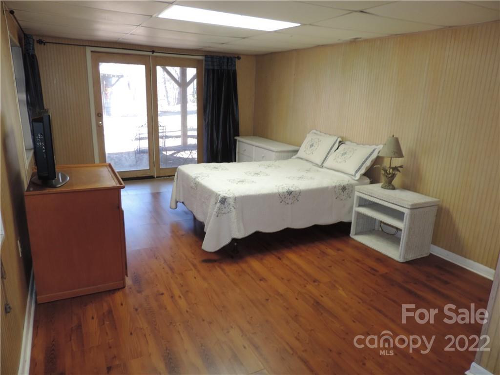3284 Lake Logan Road Canton, NC 28716 - Photo 23 of 44 a spacious bedroom with a bed and wooden floor