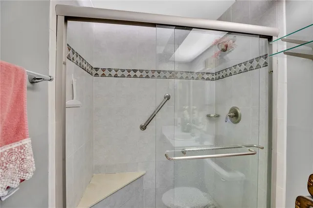 a bathroom with a shower and a glass shower door