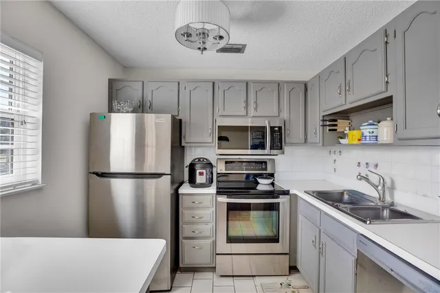 a kitchen with stainless steel appliances a refrigerator sink and microwave