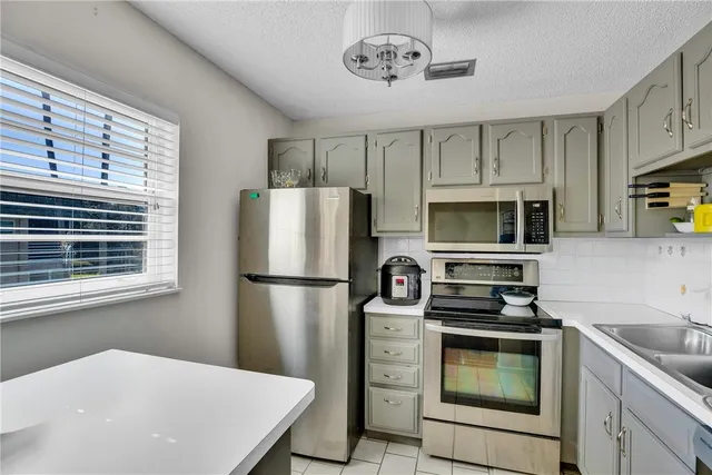 a kitchen with refrigerator cabinets and window