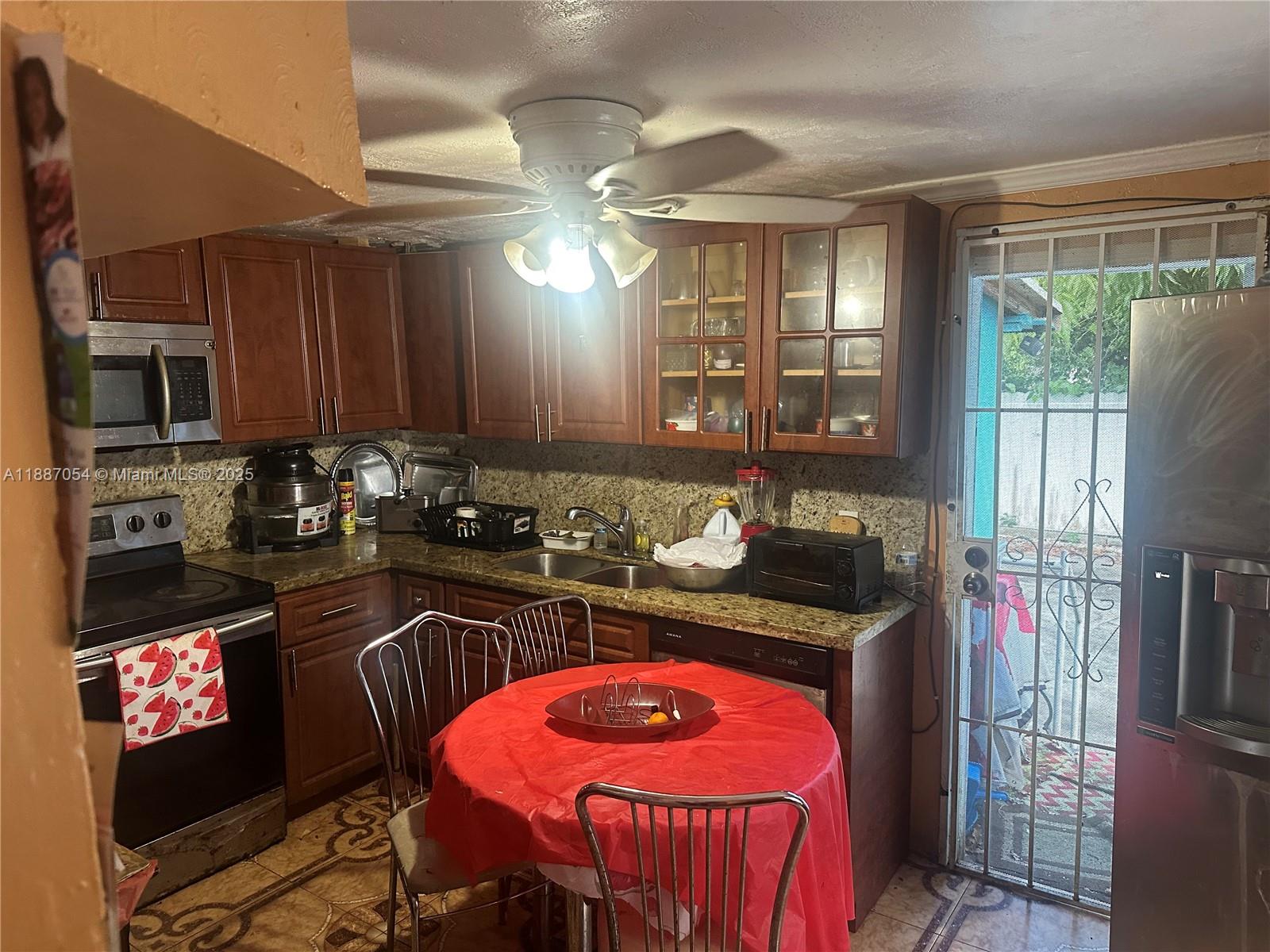 390 Northeast 166th Street Miami, FL 33162 - Photo 2 of 10 a kitchen with stainless steel appliances granite countertop a stove a sink and a refrigerator
