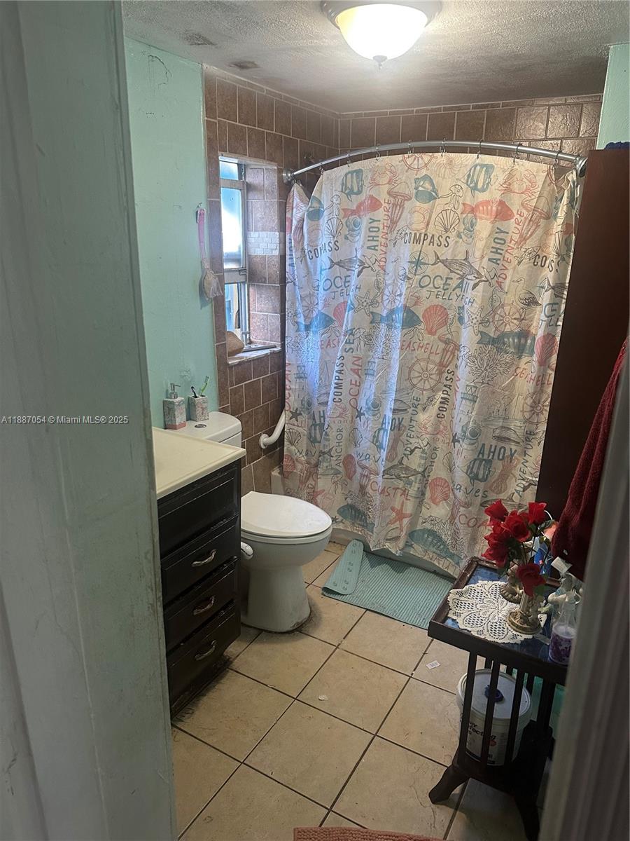 390 Northeast 166th Street Miami, FL 33162 - Photo 6 of 10 a bathroom with a sink toilet and shower
