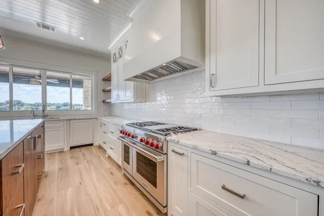 a kitchen with a stove and white cabinets