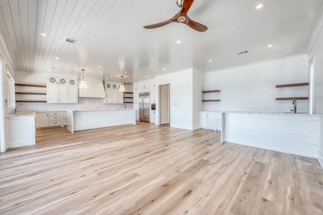 a large kitchen with stainless steel appliances kitchen island a large counter top and a sink