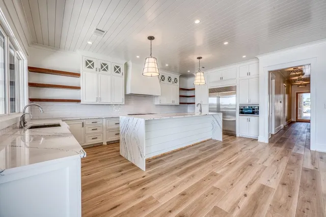 a large kitchen with stainless steel appliances kitchen island granite countertop a sink and cabinets