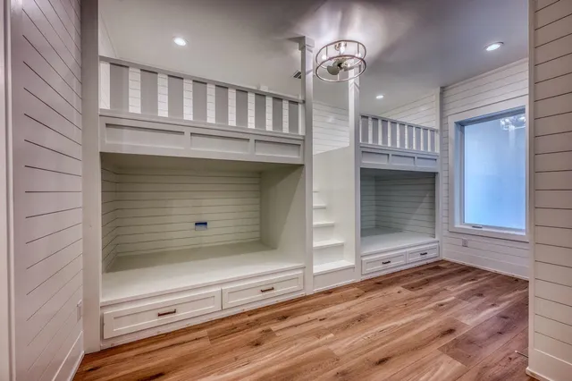 an empty room with wooden floor and staircase