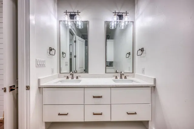 a bathroom with a double vanity sink and mirror