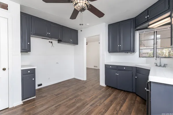 a view of a kitchen with a sink dishwasher a refrigerator and wooden cabinets