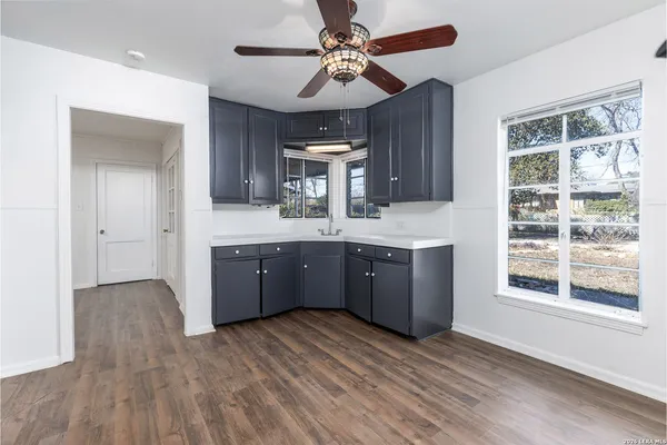 a kitchen with stainless steel appliances granite countertop a sink cabinets and wooden floor