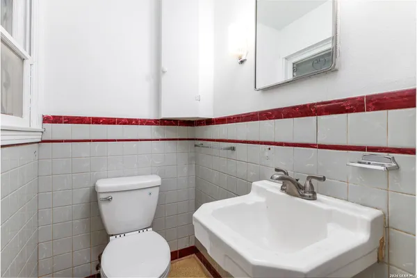 a bathroom with a sink a toilet and mirror