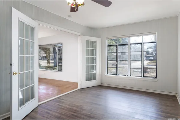 an empty room with wooden floor and windows