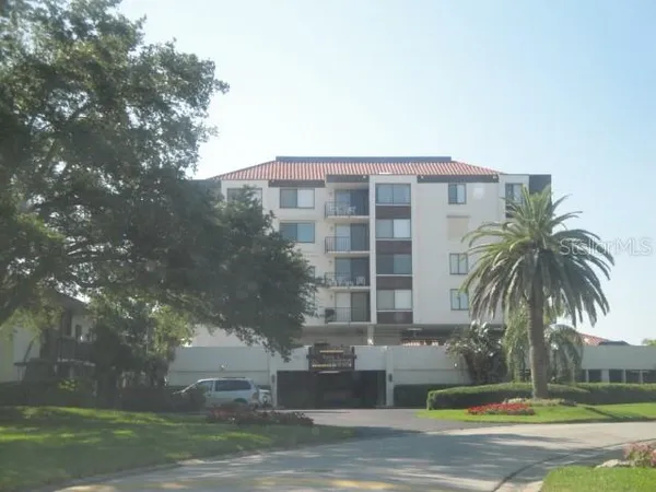 a front view of a multi story building with yard