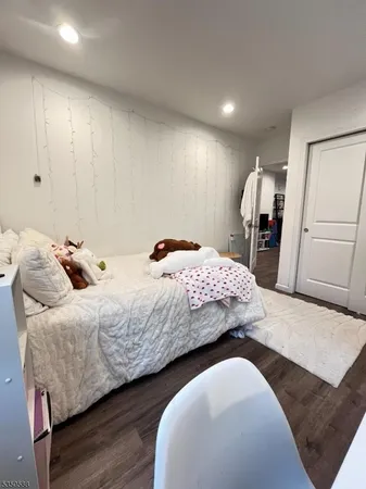 a bedroom with bed and wooden floor