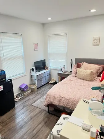 a bedroom with bed and wooden floor