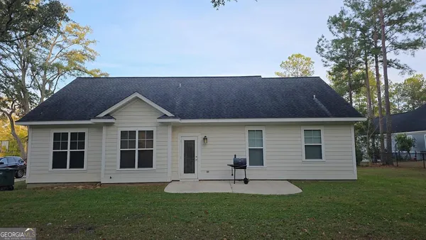 a front view of a house with a garden and yard