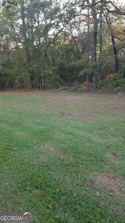 a view of a field with trees in background