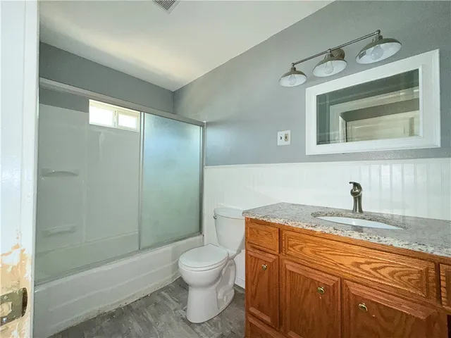 a bathroom with a granite countertop sink toilet and shower