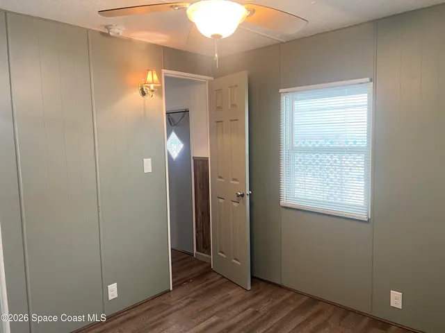 an empty room with wooden floor and a window
