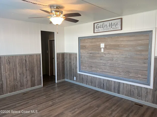 a view of wooden floor and chandelier fan in a room