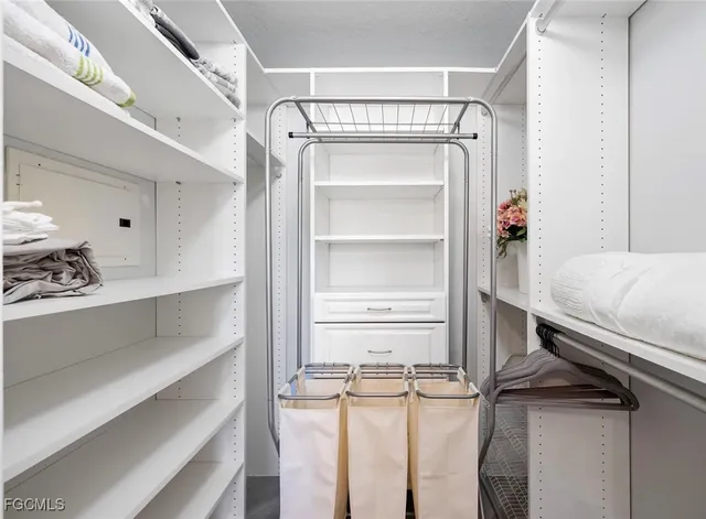 a view of walk in closet with empty racks