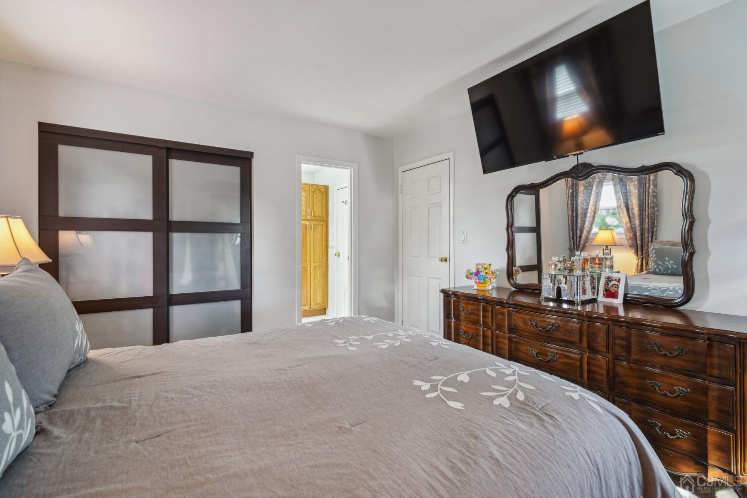 418 Durham Avenue Edison, NJ 08817 - Photo 13 of 30 a bedroom with a large bed and a flat screen tv